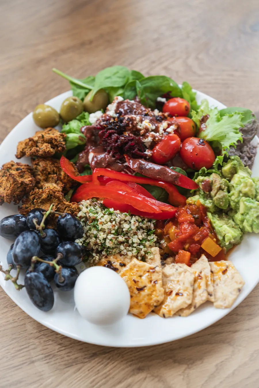 Grande assiette composée : salade, tomates cerises, taboulé, raisins, œuf et galettes